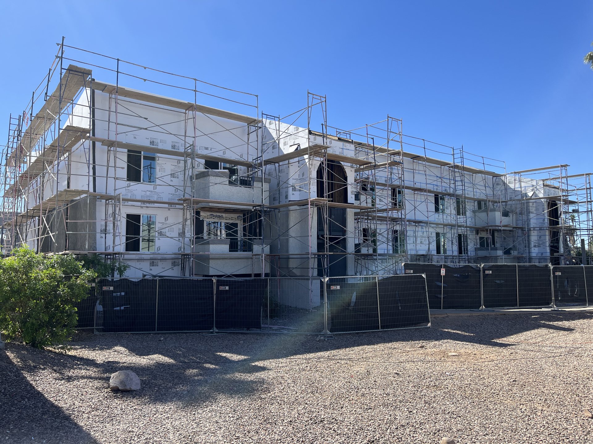 Apartment building under scaffolding with rigid foam insulation board installed over the exterior walls before new stucco